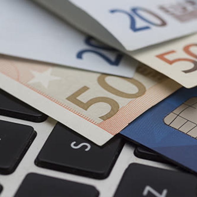 Klavyede 20 ve 50 Euro banknotlar ve mavi bir banka kartı var.