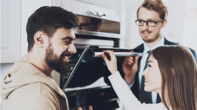 Bir mutfakta, sakallı bir adam, bir kadın ve gözlüklü bir adam fırını inceliyorlar.