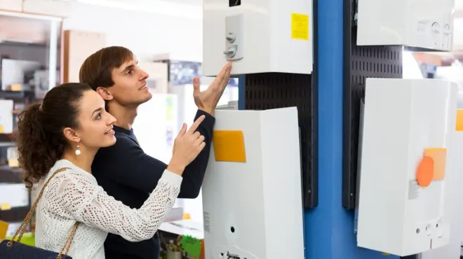 Bir çift, beyaz eşyaları inceliyor. Kadın beyaz dantel bir bluz, adam ise koyu renk bir kazak giymiş.