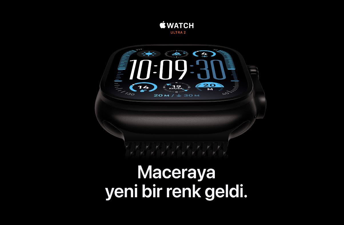 Siyah arka planda, mavi ekranlı siyah Apple Watch Ultra 2 saat 10:09:30'u gösteriyor. Ekranında küçük simgeler ve "WATCH ULTRA 2" yazısı var.