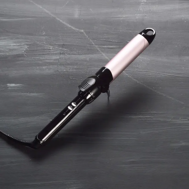 Siyah zemin üzerinde pembe ve siyah saç maşası duruyor.